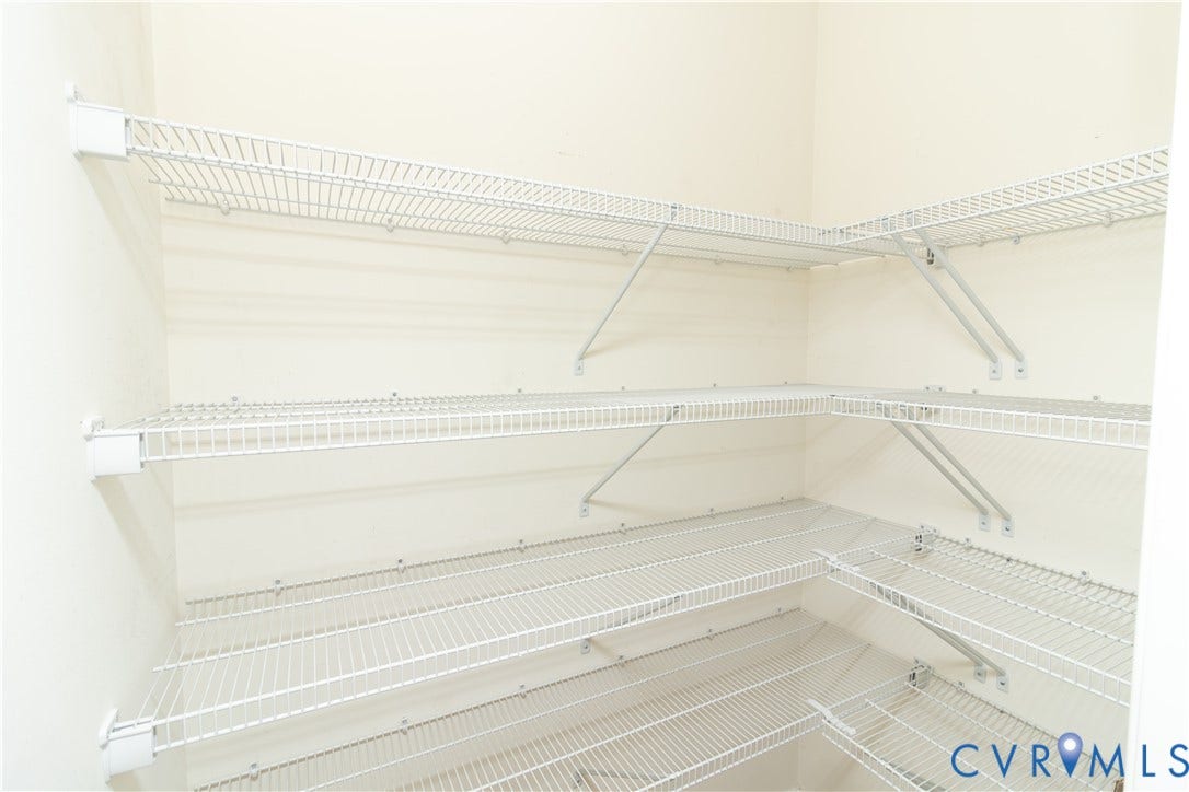 Built-in wire shelving system with multiple tiers, extending along two walls