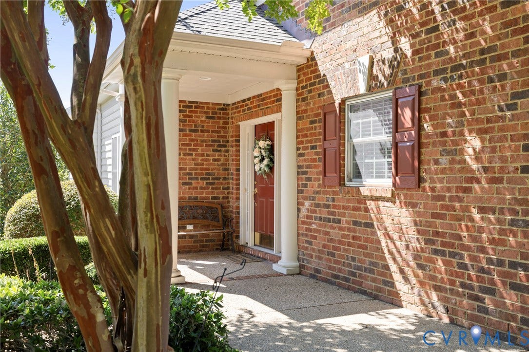 14119 Shawhan Place, Charter Colony, Midlothian, VA 23114 Brick exterior with a covered entry, white columns, a red entry door, and a single window with red shutters