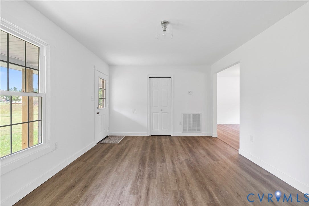 7621 Amelia Springs Road, Amelia, VA 23083 White interior walls, wood-finish flooring, white trim, and a window with exterior visibility
