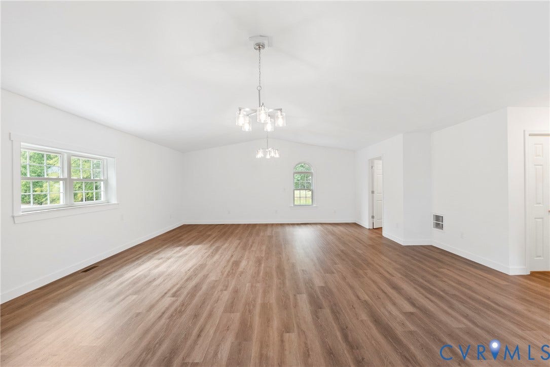 7621 Amelia Springs Road, Amelia, VA 23083 Vaulted white ceilings, wood-finish flooring, two modern chandeliers, and multiple windows