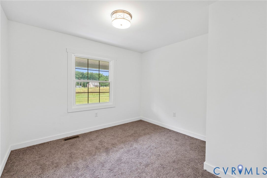 7621 Amelia Springs Road, Amelia, VA 23083 Recessed ceiling light fixture, white interior walls, carpet flooring, and a large window with grid panes