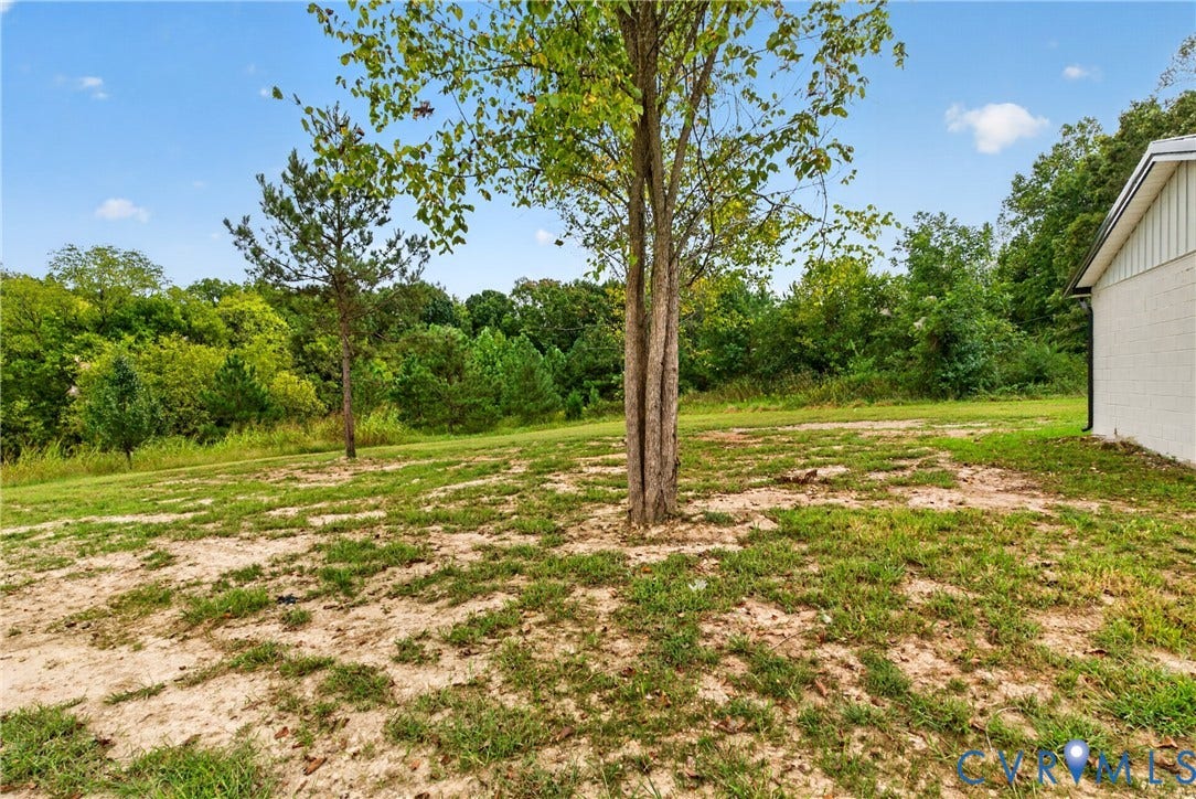 7621 Amelia Springs Road, Amelia, VA 23083 Expansive outdoor space featuring existing tree, natural landscaping, and a partial exterior wall with horizontal siding