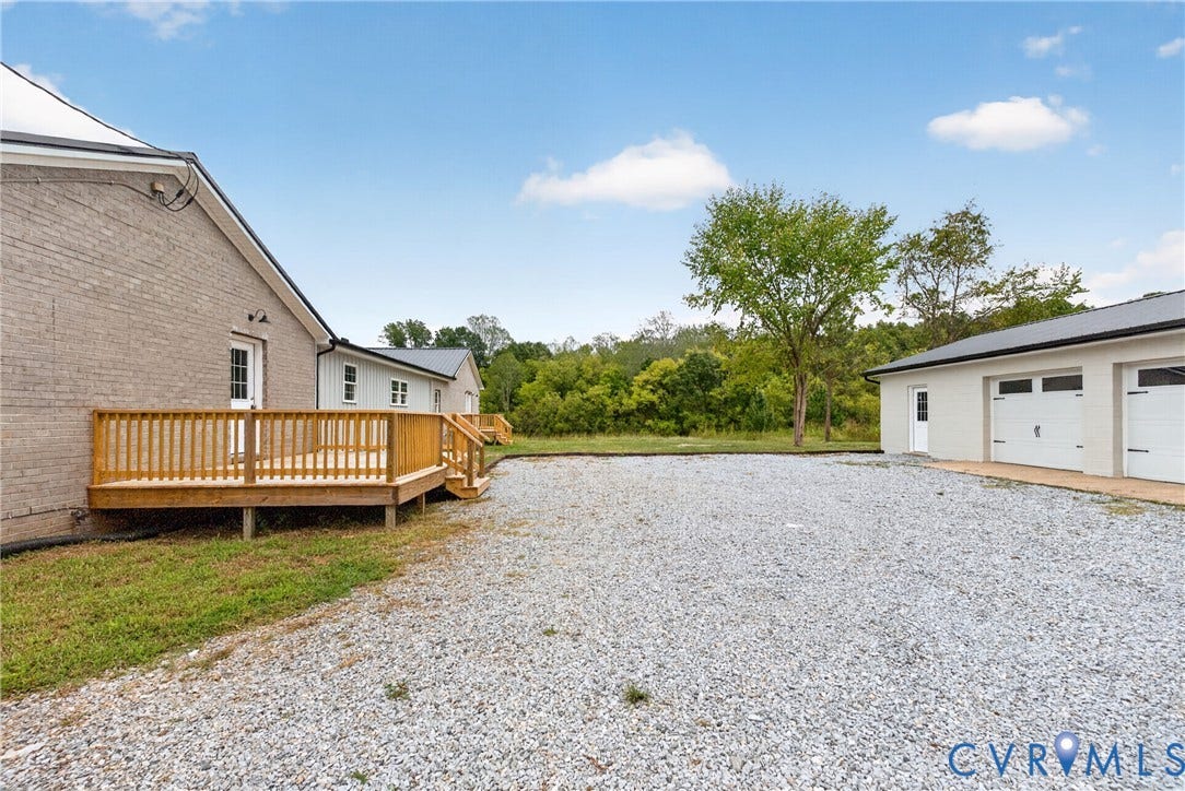 7621 Amelia Springs Road, Amelia, VA 23083 Spacious gravel area, multi-car garage, and a wood deck with railings