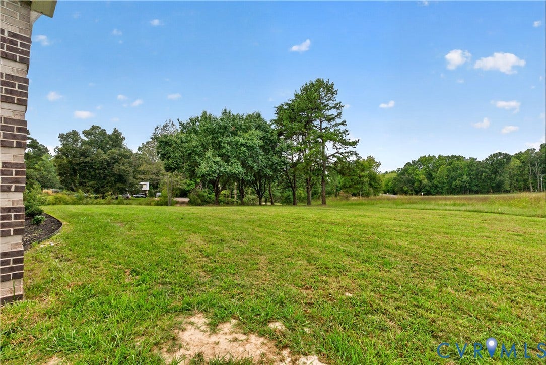 7621 Amelia Springs Road, Amelia, VA 23083 Expansive green lawn with mature trees and a brick-clad architectural element