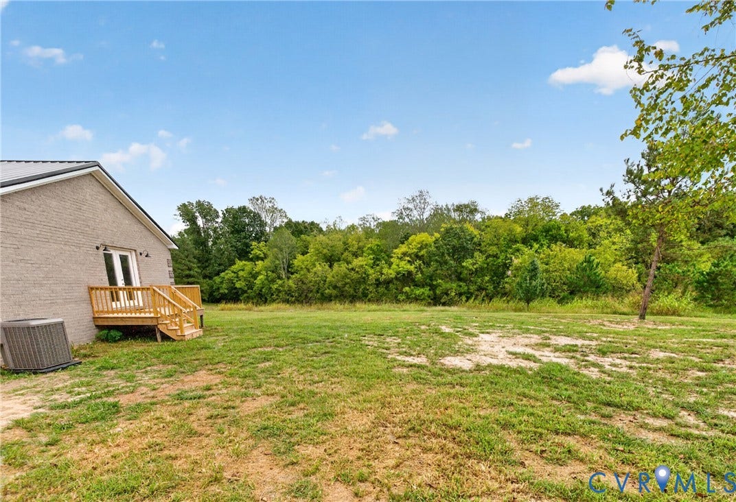 7621 Amelia Springs Road, Amelia, VA 23083 Expansive outdoor space featuring a wood deck, double doors, and a brick exterior