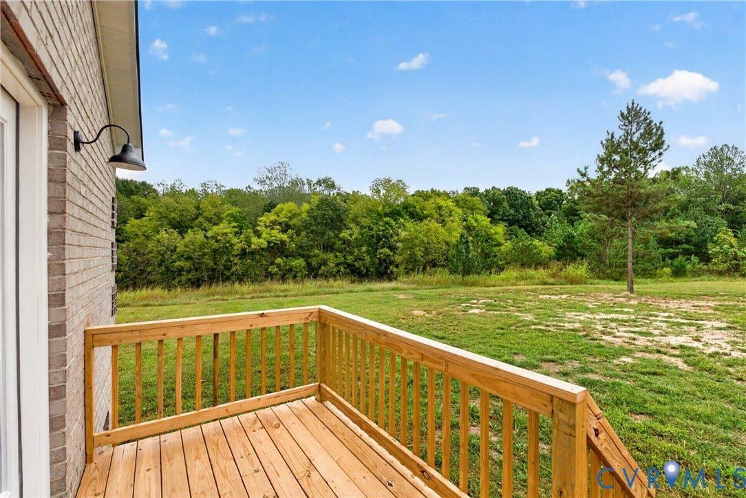 7621 Amelia Springs Road, Amelia, VA 23083 Wood deck with natural wood railing, brick exterior, and gooseneck exterior lighting