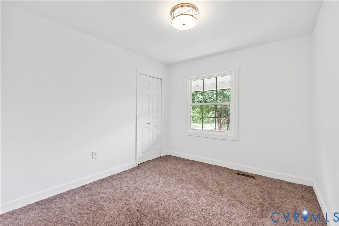 7621 Amelia Springs Road, Amelia, VA 23083 Recessed window with white trim, brown carpet flooring, white walls, bi-fold closet door, and a flush-mount ceiling light