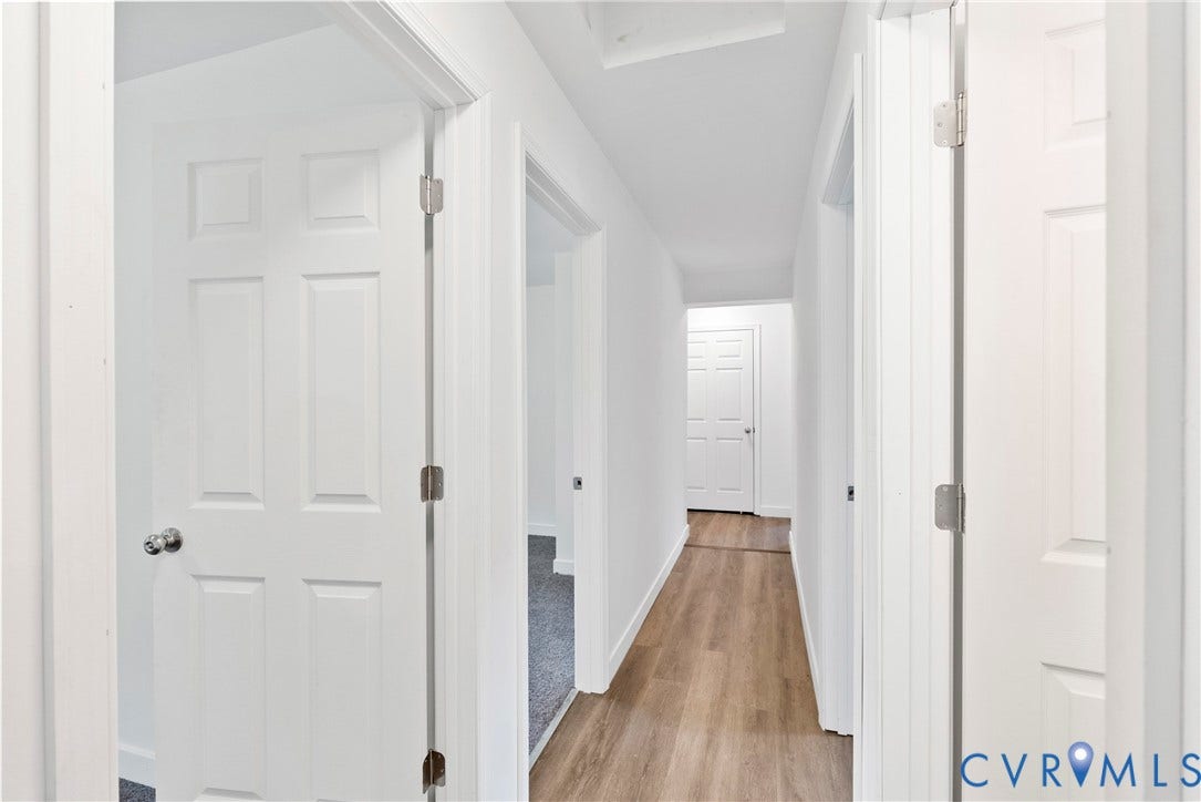 7621 Amelia Springs Road, Amelia, VA 23083 Hallway with wood-finish flooring and multiple white paneled doors