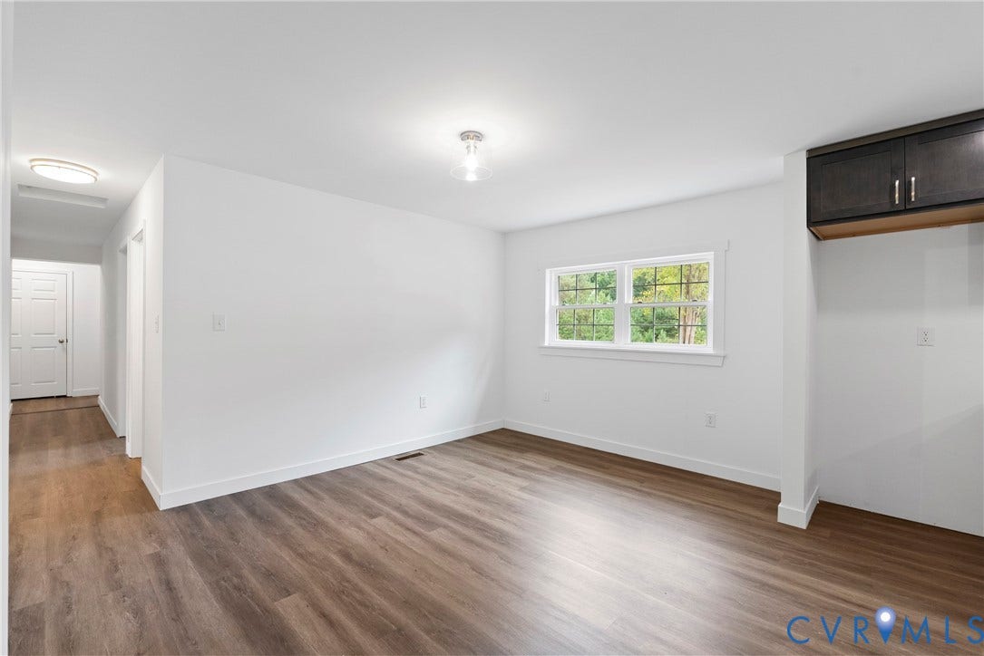 7621 Amelia Springs Road, Amelia, VA 23083 Wood-finish flooring, white painted walls, a window with exterior views, and upper cabinetry