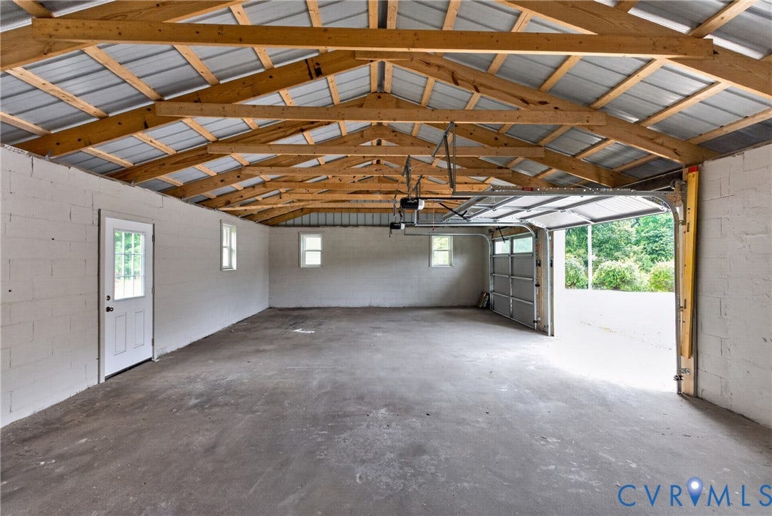 7621 Amelia Springs Road, Amelia, VA 23083 Concrete flooring with an exposed wood truss ceiling, white block walls, and multiple windows