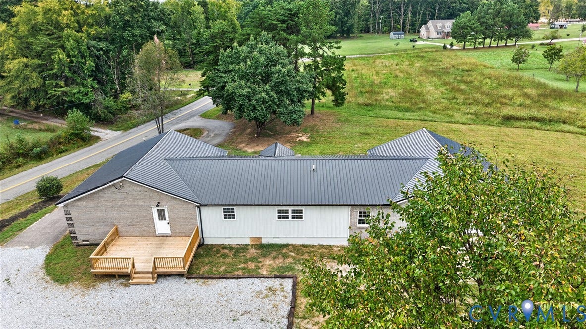 7621 Amelia Springs Road, Amelia, VA 23083 Newly constructed deck, metal roofing, light-colored brick exterior, light-toned siding, and a gravel driveway