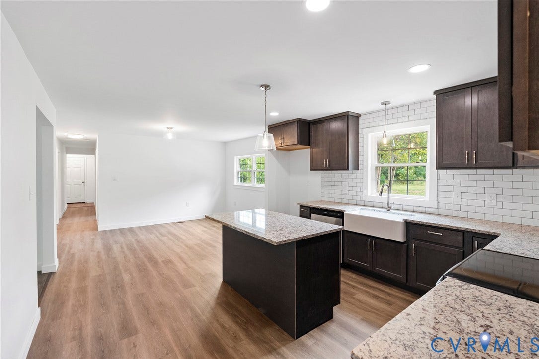 7621 Amelia Springs Road, Amelia, VA 23083 Modern kitchen featuring dark wood cabinetry, light-toned countertops, a white subway tile backsplash, and a farmhouse-style sink