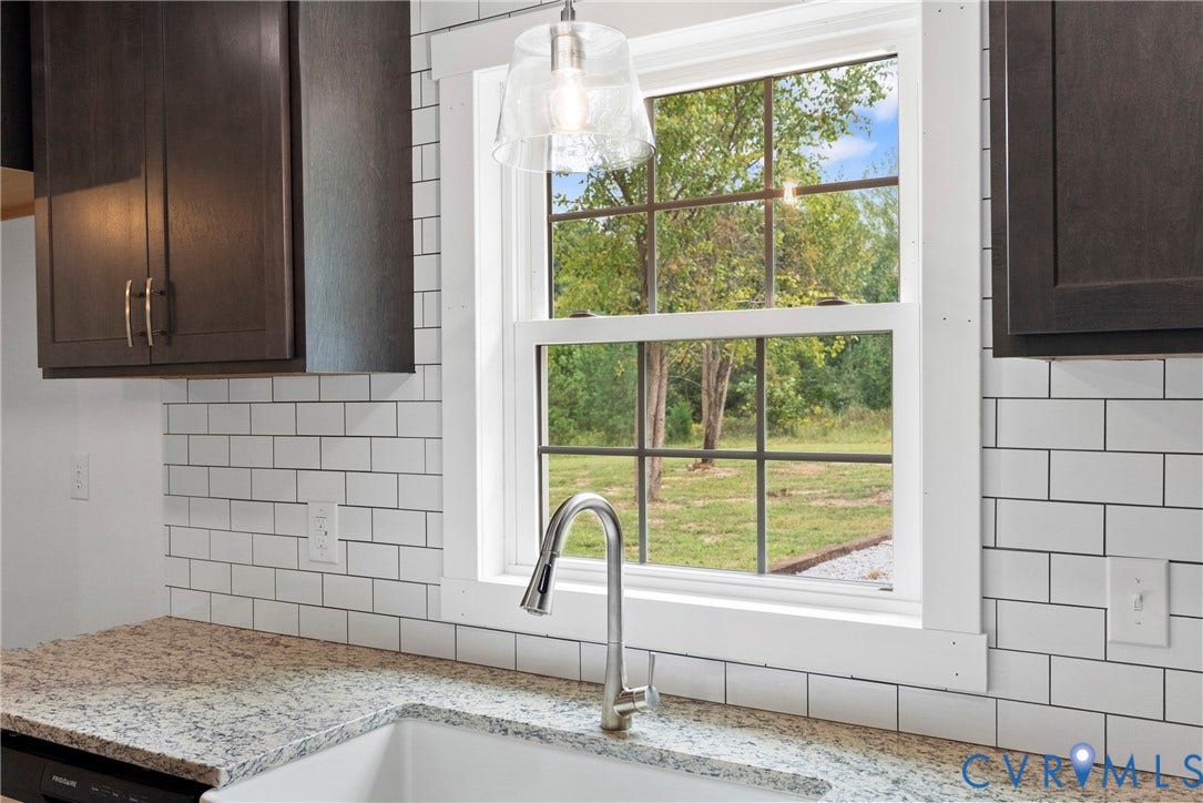 7621 Amelia Springs Road, Amelia, VA 23083 Kitchen area featuring dark wood-finish cabinetry, a white subway tile backsplash, and a light-colored speckled countertop