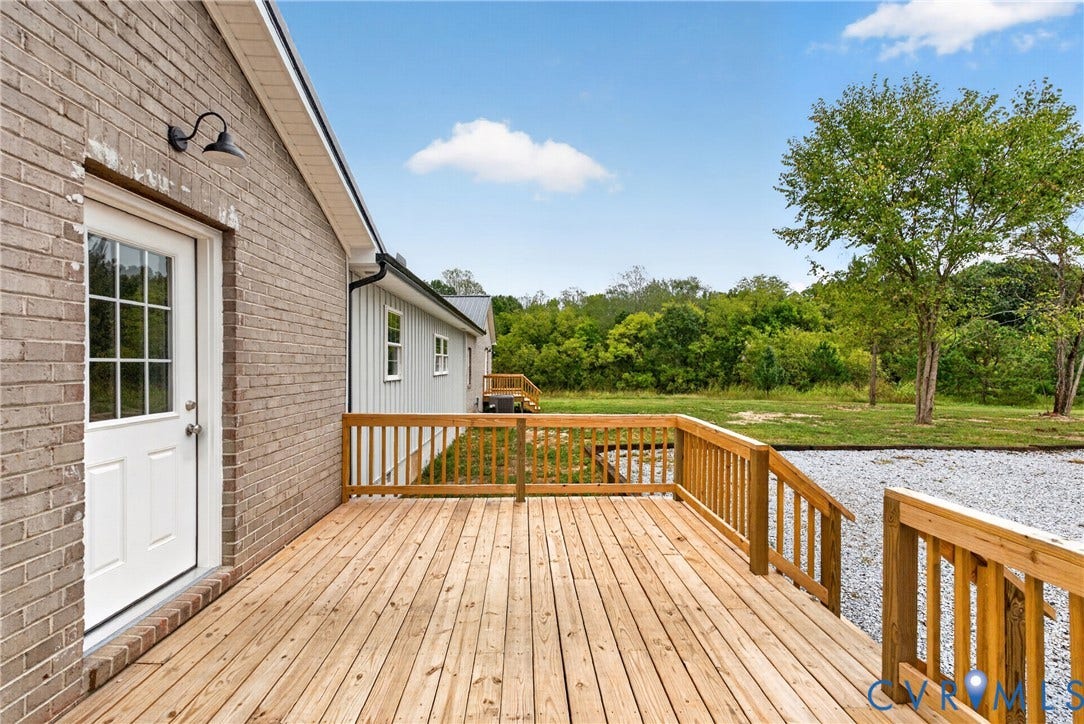 7621 Amelia Springs Road, Amelia, VA 23083 Expansive wood deck with natural wood railing, leading to a gravel area