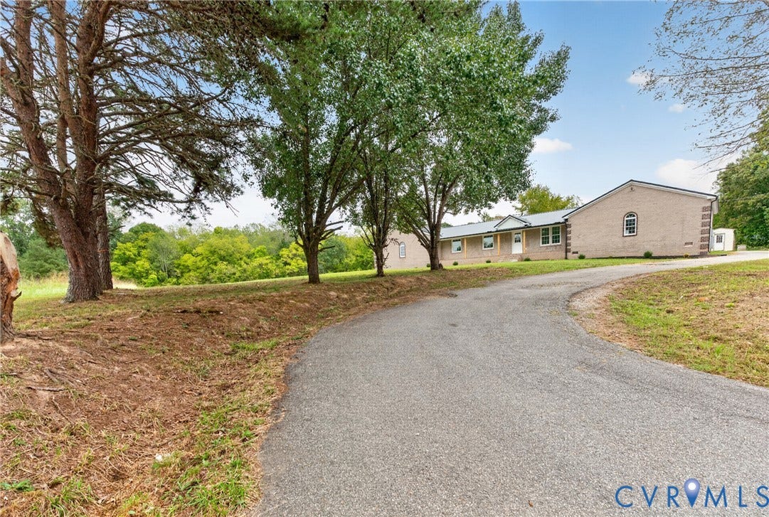 7621 Amelia Springs Road, Amelia, VA 23083 Paved drive leading to the property with mature trees and a brick exterior