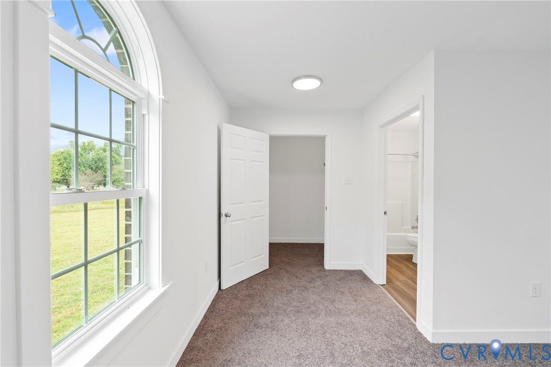 7621 Amelia Springs Road, Amelia, VA 23083 Arched window, white trim, carpeted flooring, flush mount lighting, and wood-finish flooring