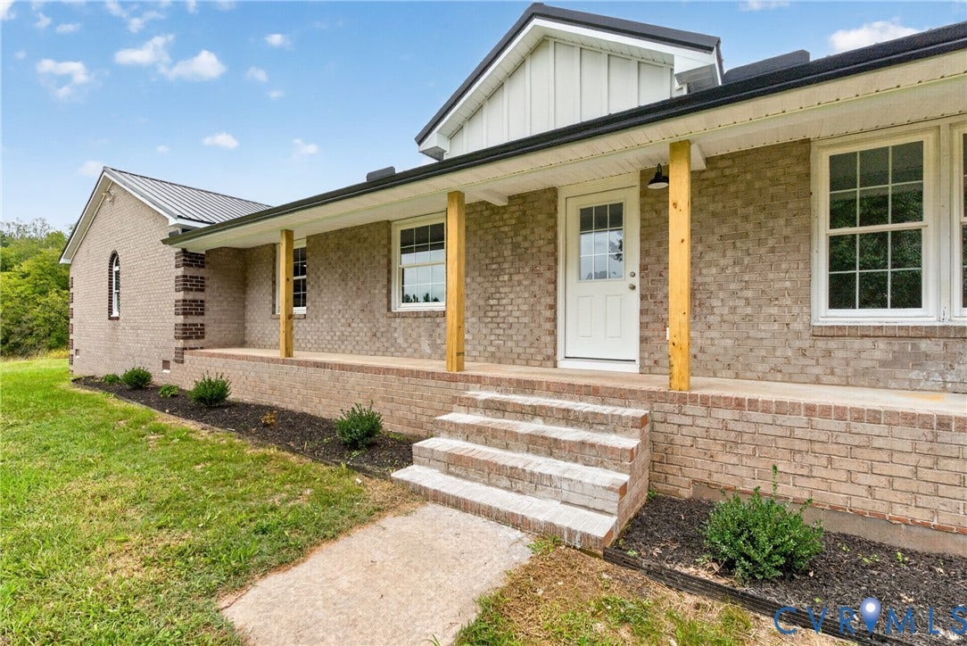 7621 Amelia Springs Road, Amelia, VA 23083 Brick exterior with a metal roof, covered front porch, and natural wood support columns