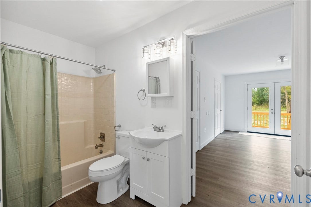 7621 Amelia Springs Road, Amelia, VA 23083 Bathroom featuring a shower-tub combination with tile surround, white vanity, and wood-finish flooring