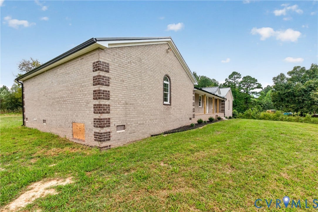 7621 Amelia Springs Road, Amelia, VA 23083 Brick exterior with contrasting brick corner detailing, arched window, covered porch entry, and expansive lawn