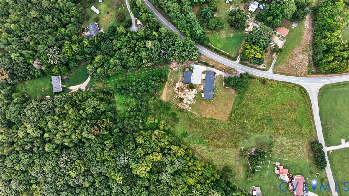 7621 Amelia Springs Road, Amelia, VA 23083 Expansive property featuring a main residence with a dark-pitched roof, a secondary structure, abundant mature trees, and direct road frontage