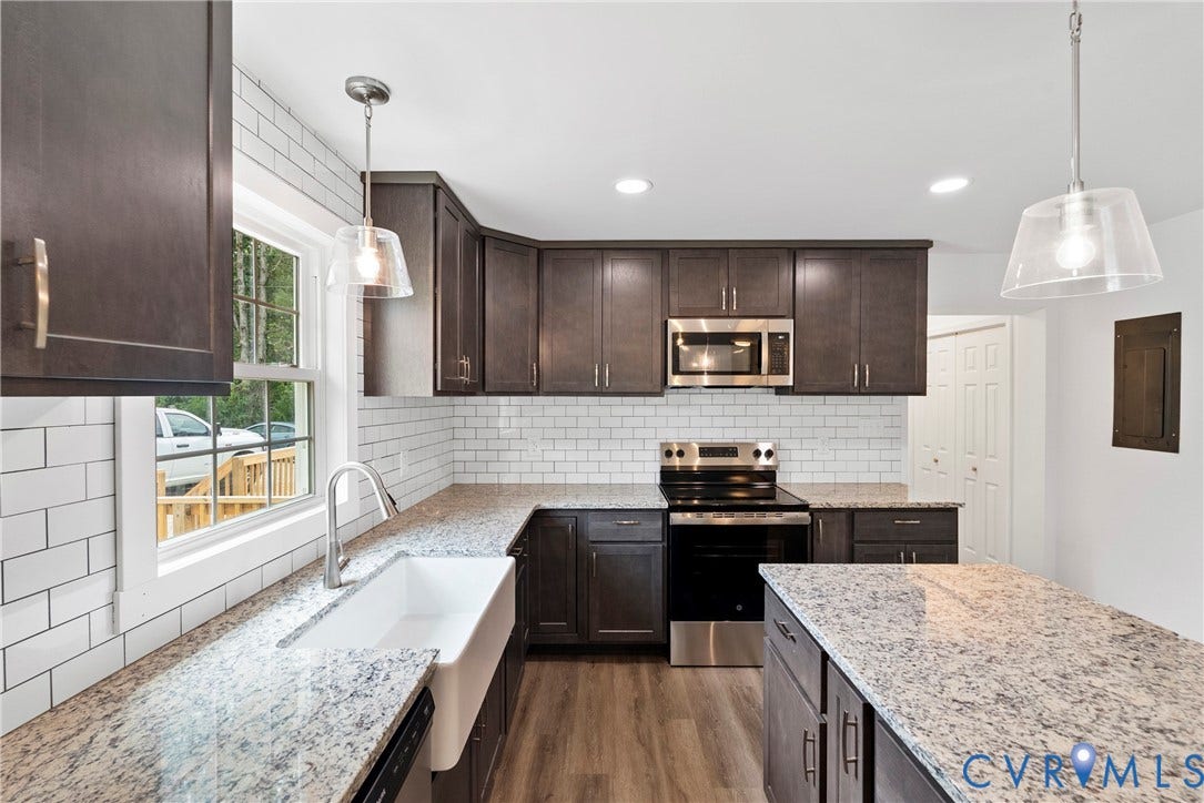 7621 Amelia Springs Road, Amelia, VA 23083 Kitchen featuring dark wood-finish cabinetry, light speckled countertops, white subway tile backsplash, stainless steel appliances, and wood-finish flooring