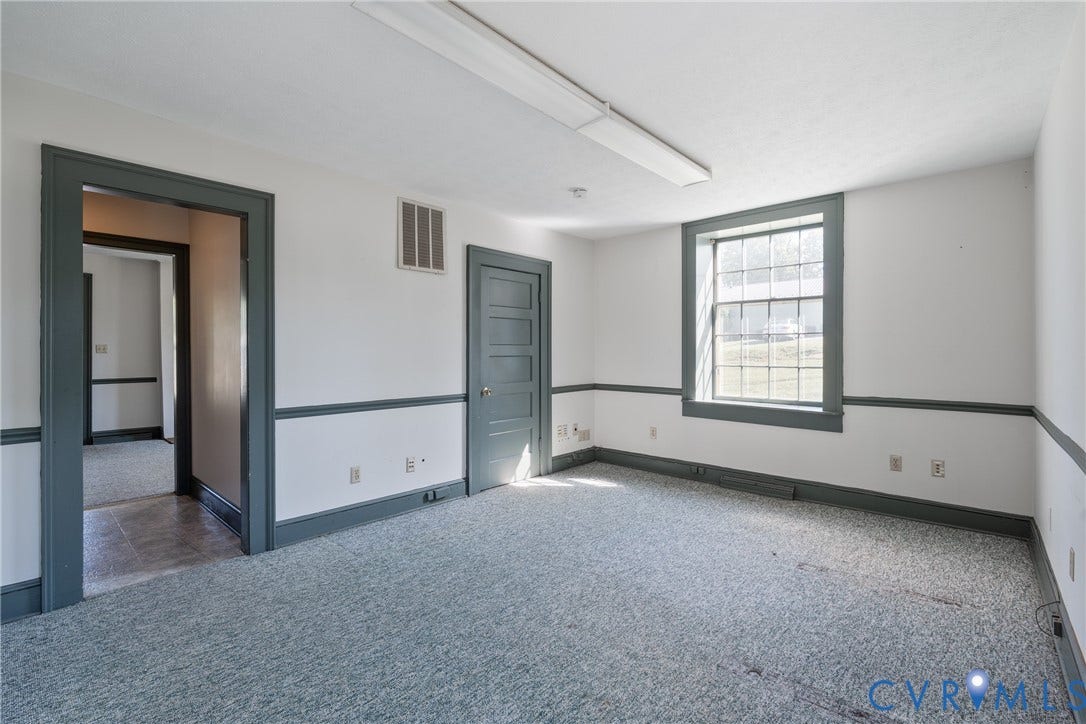 13085 W James Anderson Highway, Buckingham, VA 23921 Room featuring a single-pane window, carpeted flooring, and a paneled door