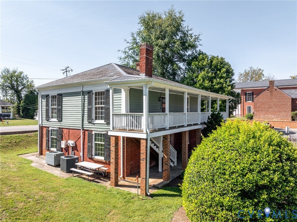 13085 W James Anderson Highway, Buckingham, VA 23921 Brick and siding exterior with a full-length covered porch, white railing, and exterior staircase