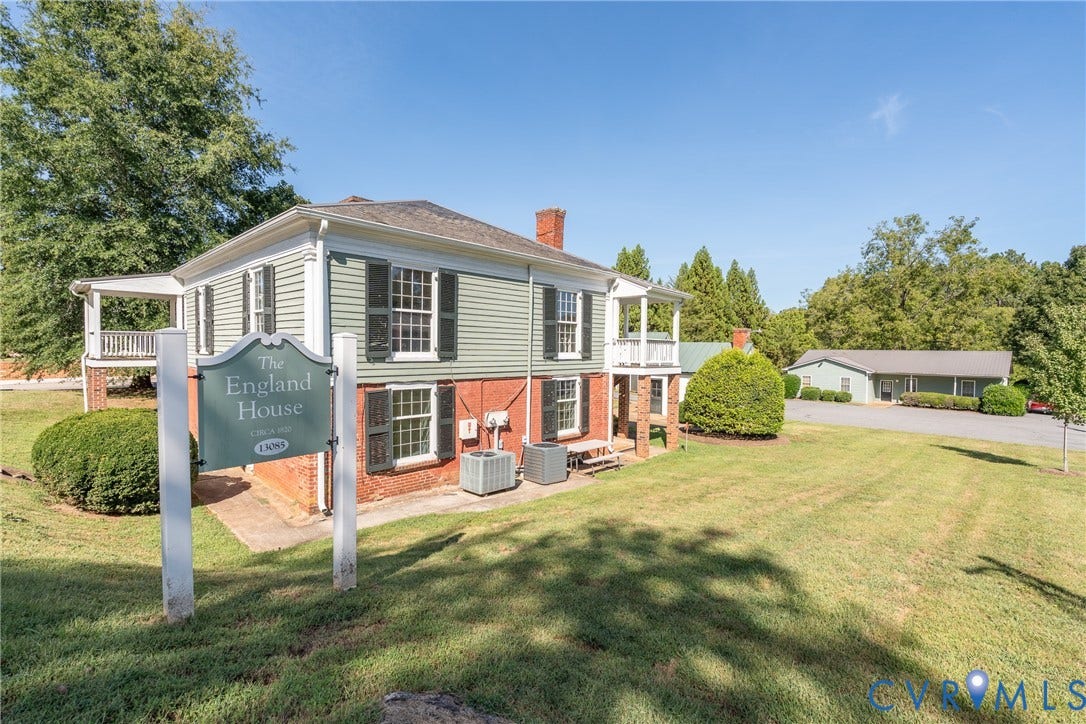 13085 W James Anderson Highway, Buckingham, VA 23921 Brick and siding exterior with dark shutters, featuring a covered porch and upper-level balcony