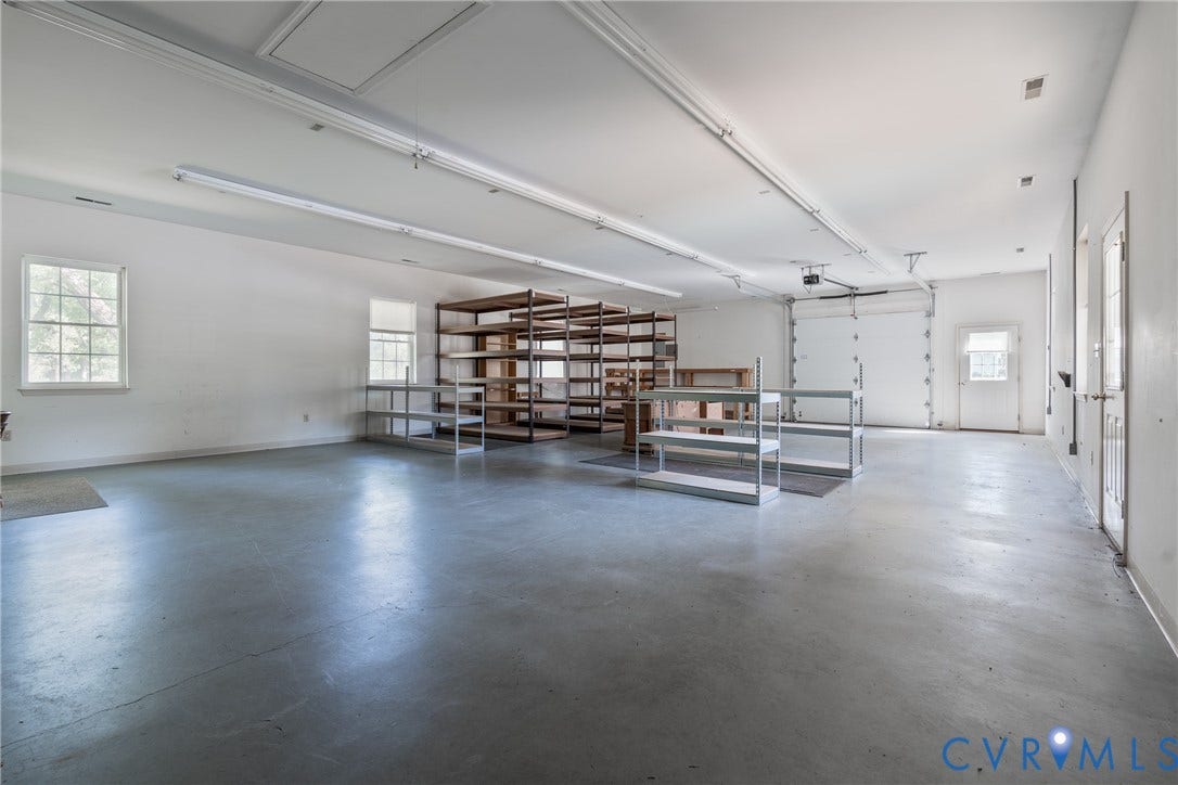 13085 W James Anderson Highway, Buckingham, VA 23921 Spacious garage with exposed concrete flooring, dual windows, and ample fluorescent lighting