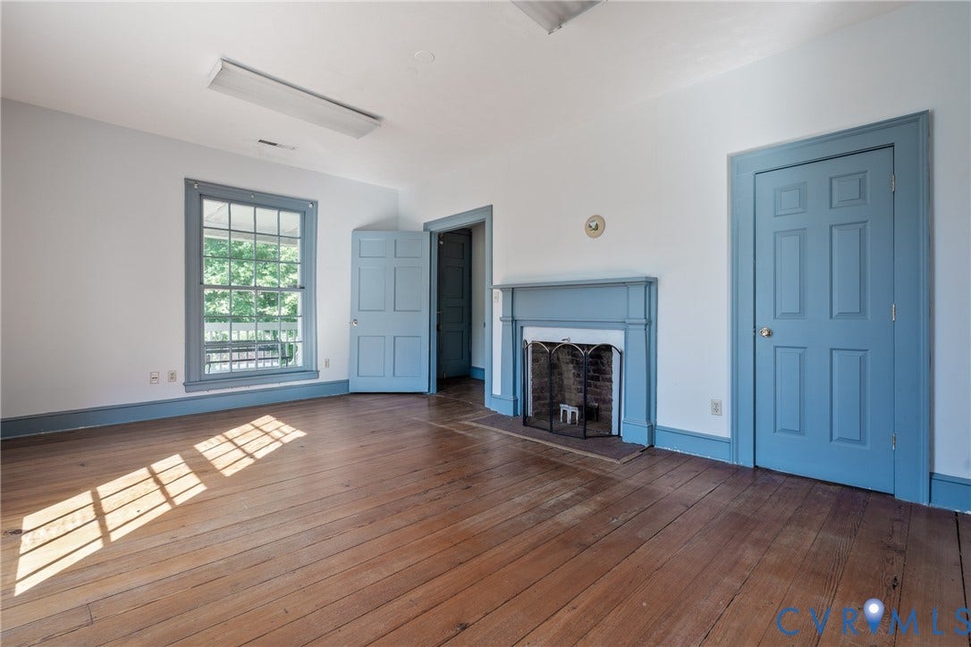 13085 W James Anderson Highway, Buckingham, VA 23921 Hardwood flooring, painted trim and doors, fireplace with mantel, and window offering exterior scenery
