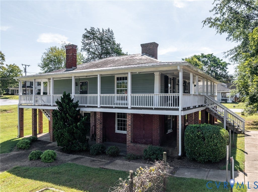 13085 W James Anderson Highway, Buckingham, VA 23921 Two-story residence featuring a full-width wraparound porch, brick foundation, and two exterior brick chimneys