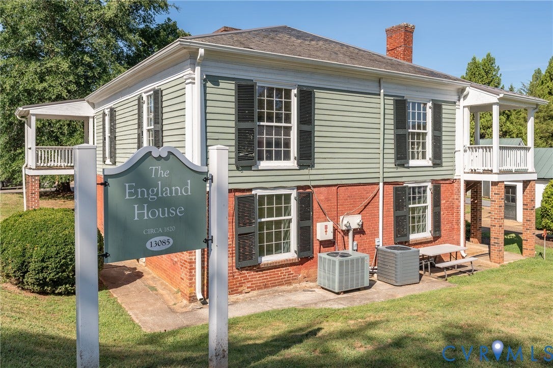 13085 W James Anderson Highway, Buckingham, VA 23921 Two-story structure with brick and horizontal siding, featuring multiple windows with shutters