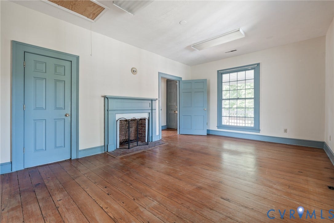13085 W James Anderson Highway, Buckingham, VA 23921 Wood-finish flooring, paneled doors, traditional fireplace with hearth, grid-pattern window, and painted trim throughout