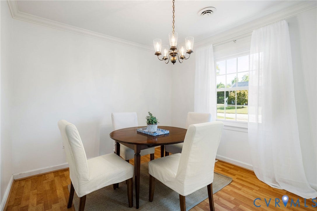 3356 Seaton Road, Petersburg, VA 23805 Crown molding accents a bright room featuring wood-finish flooring, a multi-pane window, and a chandelier lighting fixture