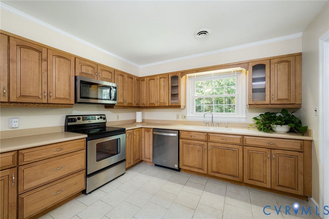 3356 Seaton Road, Petersburg, VA 23805 Kitchen featuring wood cabinetry, stainless steel appliances, a double basin sink, light-toned countertops, and tile flooring