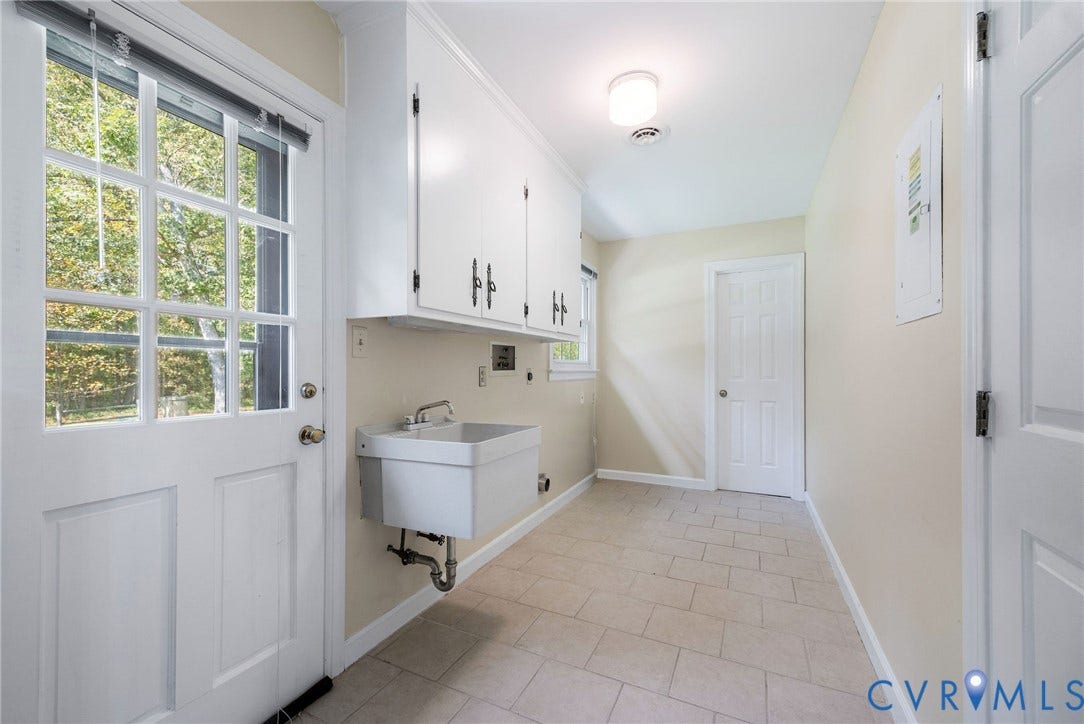 3356 Seaton Road, Petersburg, VA 23805 Laundry and mudroom. Door from garage and door to backyard. Utility sink. Tile floor, cabinets and half-bath in the back.