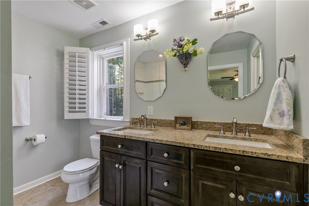 4327 Wakefield Road, Stratford Hills, Richmond, VA 23235 Dual vanity with integrated sinks, granite countertop, and dark wood-finish cabinetry
