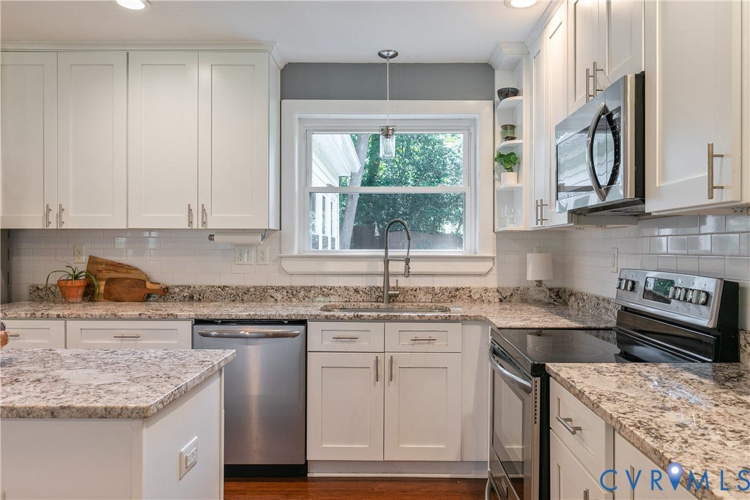 4327 Wakefield Road, Stratford Hills, Richmond, VA 23235 White shaker cabinetry, stainless steel appliances, granite countertops, subway tile backsplash, and wood-finish flooring