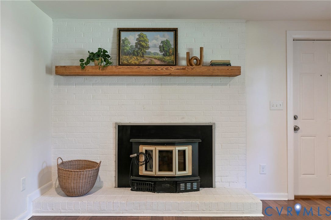 4327 Wakefield Road, Stratford Hills, Richmond, VA 23235 Painted brick fireplace with a wood-burning insert and a rustic wooden mantel
