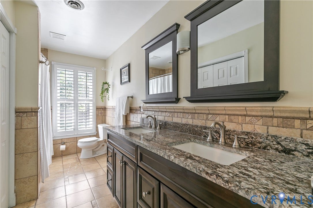 4327 Wakefield Road, Stratford Hills, Richmond, VA 23235 Dual sink vanity with stone countertop, tile flooring, and a window with plantation shutters