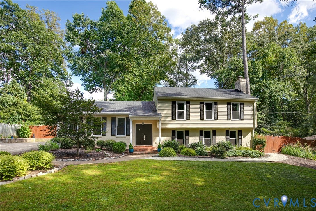 4327 Wakefield Road, Stratford Hills, Richmond, VA 23235 Split-level residence featuring a front entry, multiple windows with shutters, a brick chimney, and mature landscaping