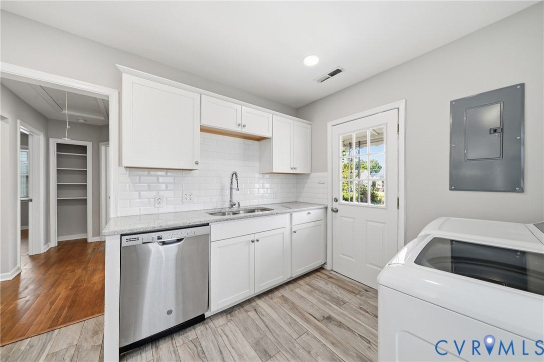 1718 Rogers, Richmond, VA 23223 White cabinetry, stainless steel dishwasher, speckled countertops, white subway tile backsplash, and light wood-finish flooring