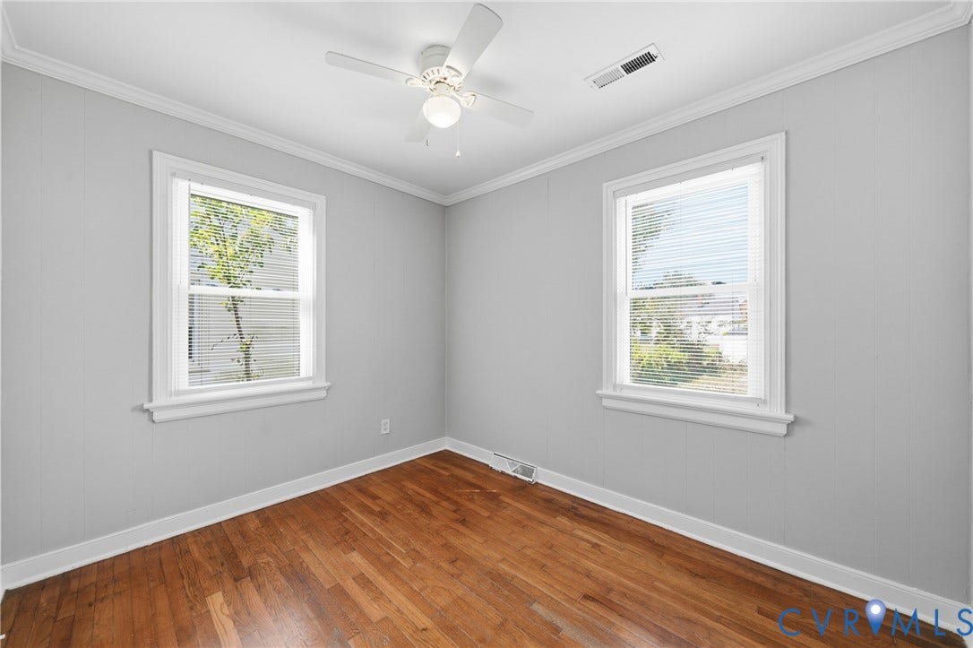 1718 Rogers, Richmond, VA 23223 Hardwood flooring, painted paneled walls, two single-hung windows with blinds, crown molding, and a ceiling fan