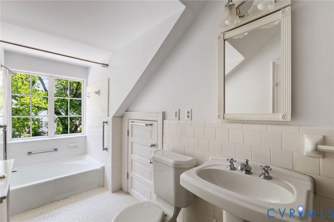 Pedestal sink with chrome fixtures, subway tile wainscoting, built-in storage, and a white tiled floor