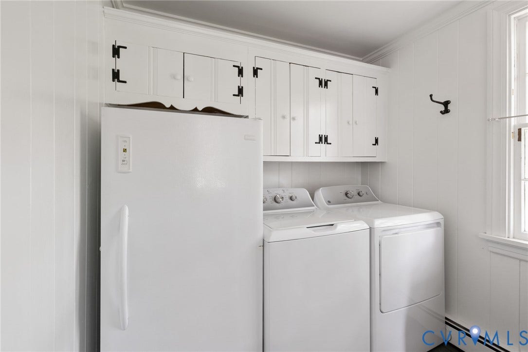 White paneled walls and built-in white cabinetry with dark hardware