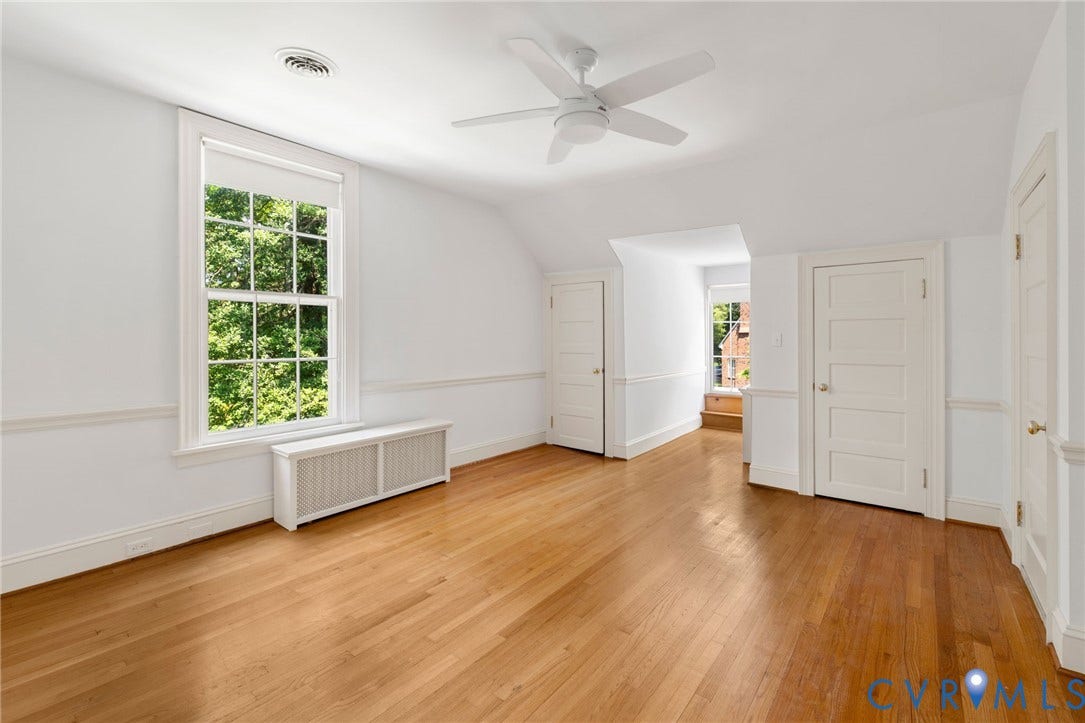 Hardwood flooring, painted paneled doors, ceiling fan, chair rail molding, and window with a white frame