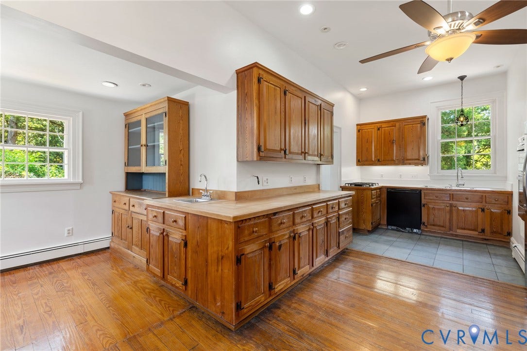 Wood-finish flooring with tile flooring, wood cabinetry, built-in cabinetry, and a ceiling fan with light fixture