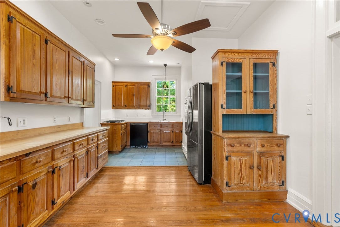 Wood-finish flooring with a ceiling fan, recessed lighting, and ample cabinetry