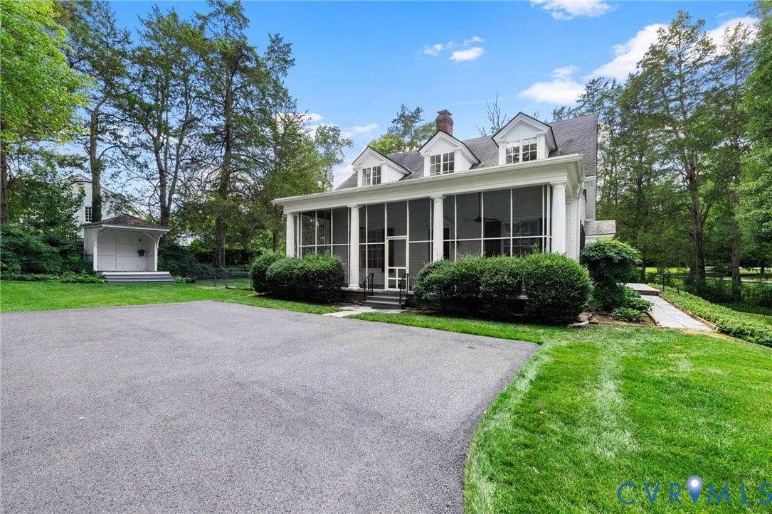 White colonial residence with dormer windows, screened-in porch, and a paved driveway