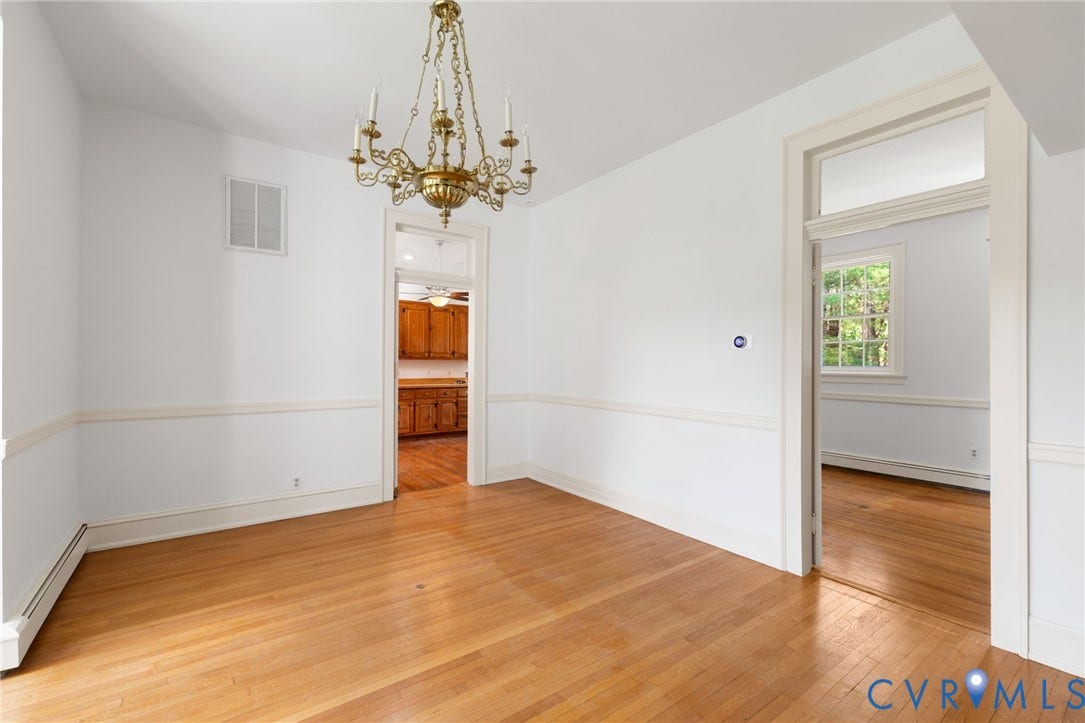 Hardwood flooring throughout, brass chandelier, chair rail molding, and white trim